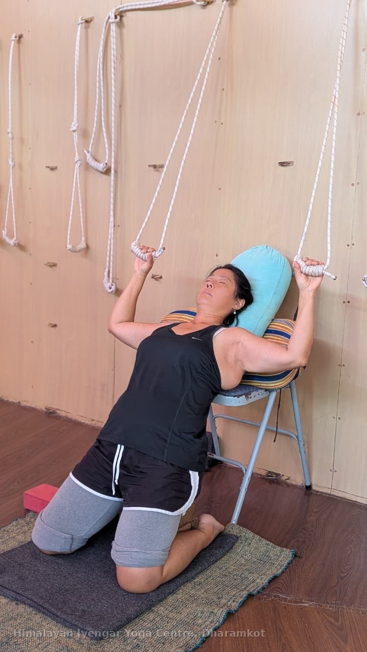 A student using ropes and a bolster in a restorative backbend at HIYC today