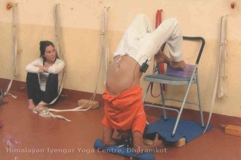 Student practising a supported headstand with a chair and blocks